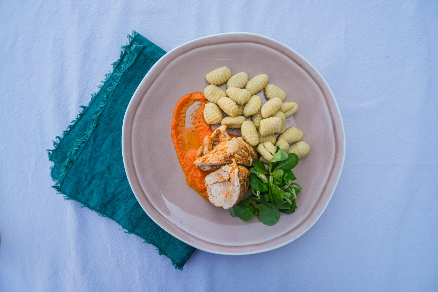 Ein Teller mit Hähnchen und Beilagen darauf